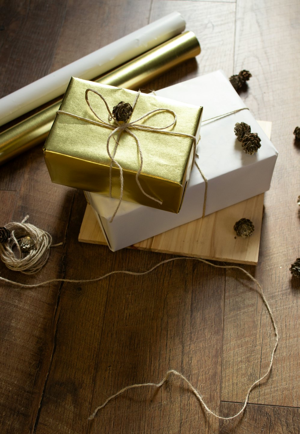 Gift boxes with wrapping supplies on a wooden floor.